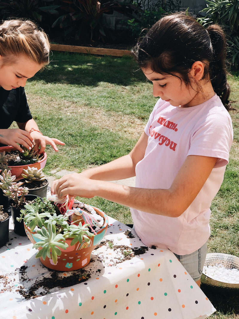 Two young girls making their own winter gardens in The Craft Parlour garden