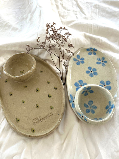 Set of ceramic dishes with floral patterns on a white fabric background