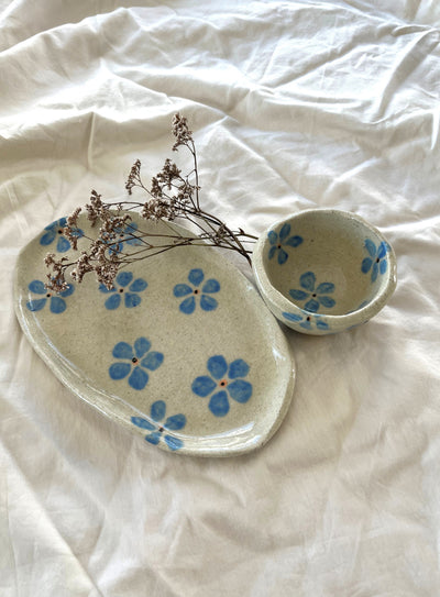 Ceramic plates with blue floral patterns on a white fabric background
