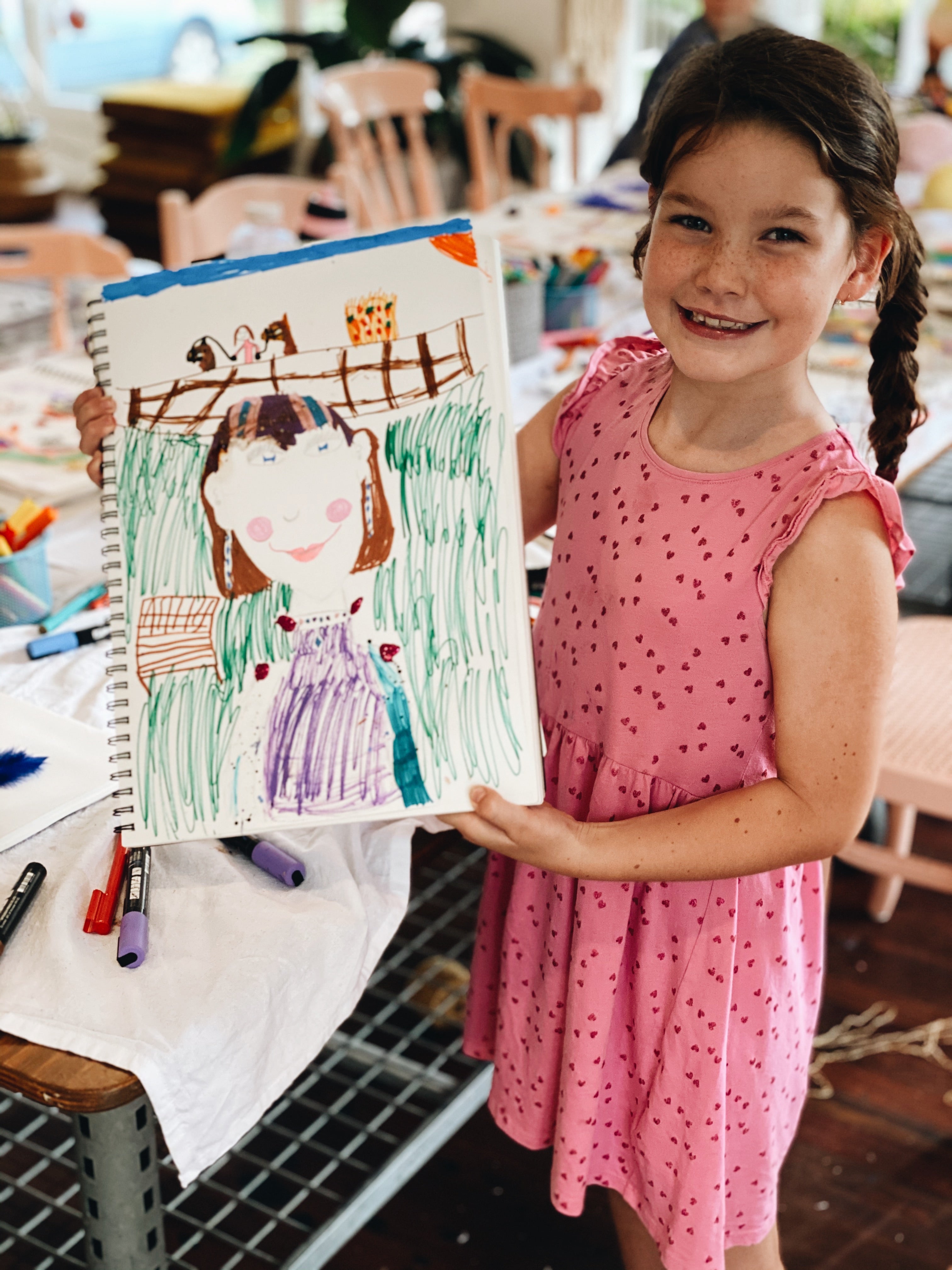 Young girl showing her drawing from Gold Coast after school craft club