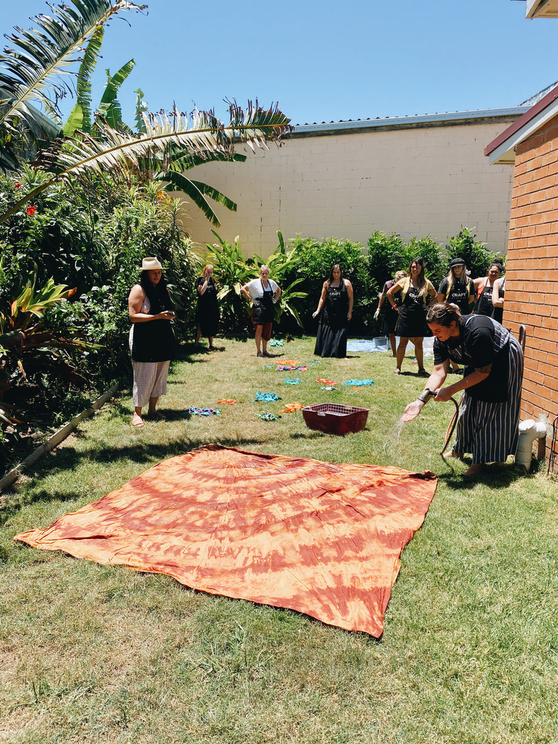 Rinsing and drying hand dyed sheet on the grass during Gold Coast workshop
