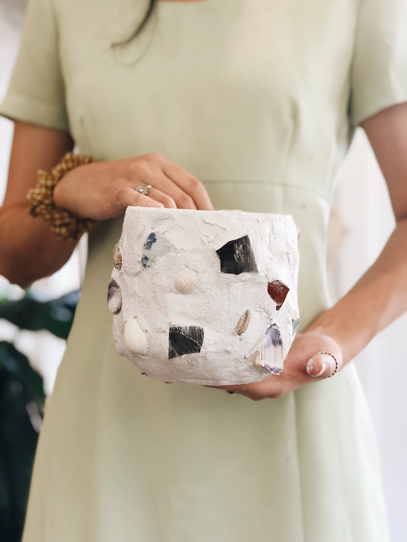 A beautiful shell mosaic pot being held up during The Craft Parlour workshop class