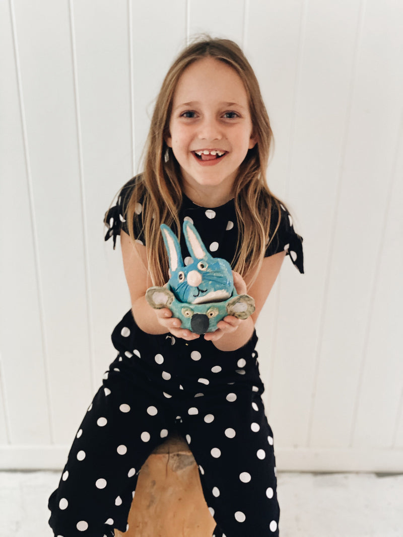 Proud smiling girl holding her handmade animal vessels