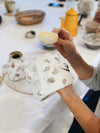 Lady making a shell mosaic pot