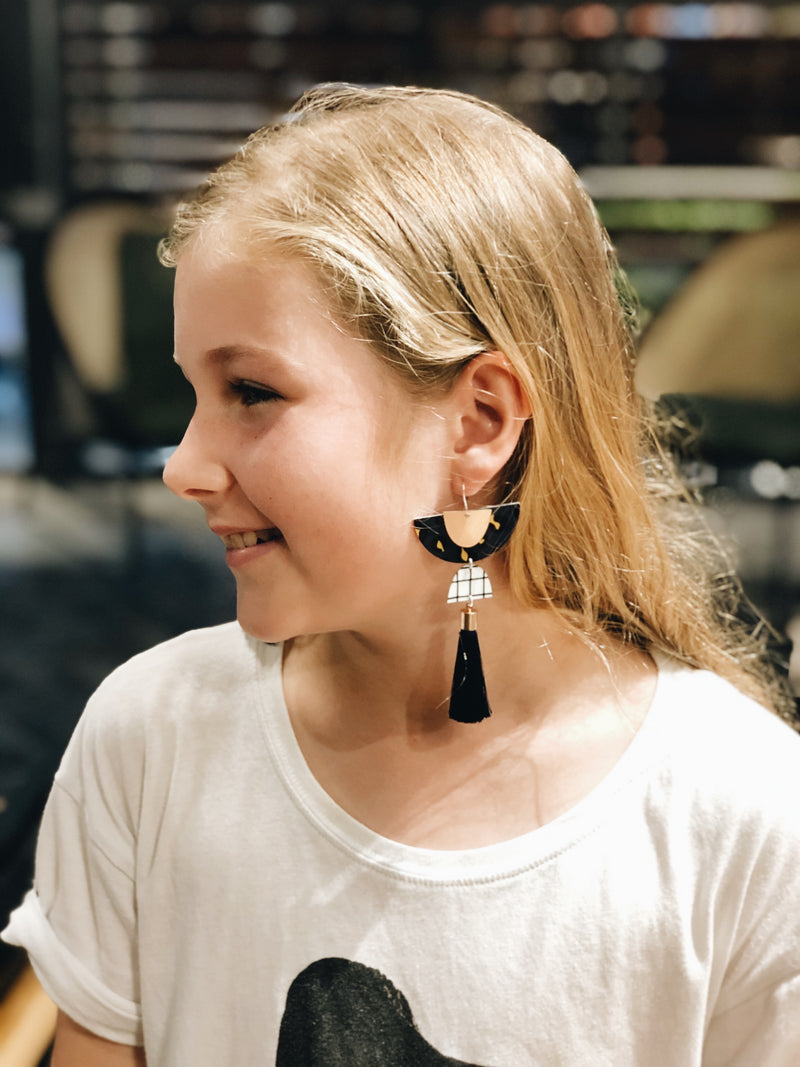 Girl with her handmade earrings made during jewellery workshop 