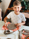 Smiling boy carving a peace sign at pottery workshop Gold coast