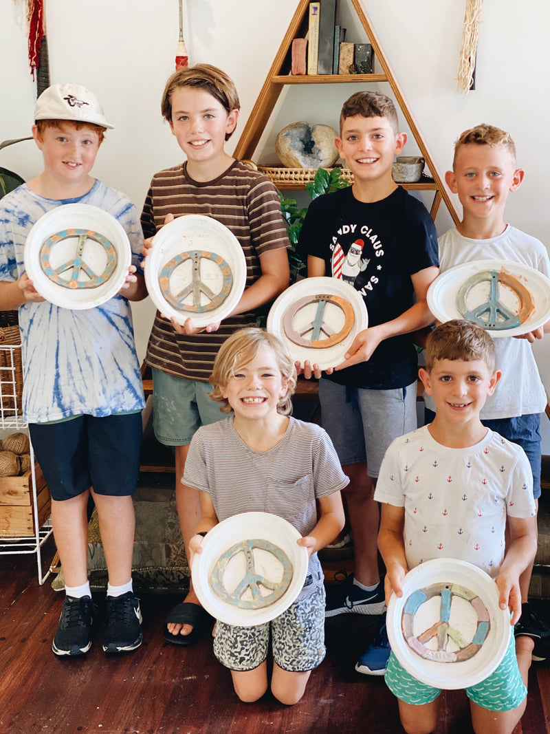 Group of boys with their finished peace signs at kids pottery class Gold Coast